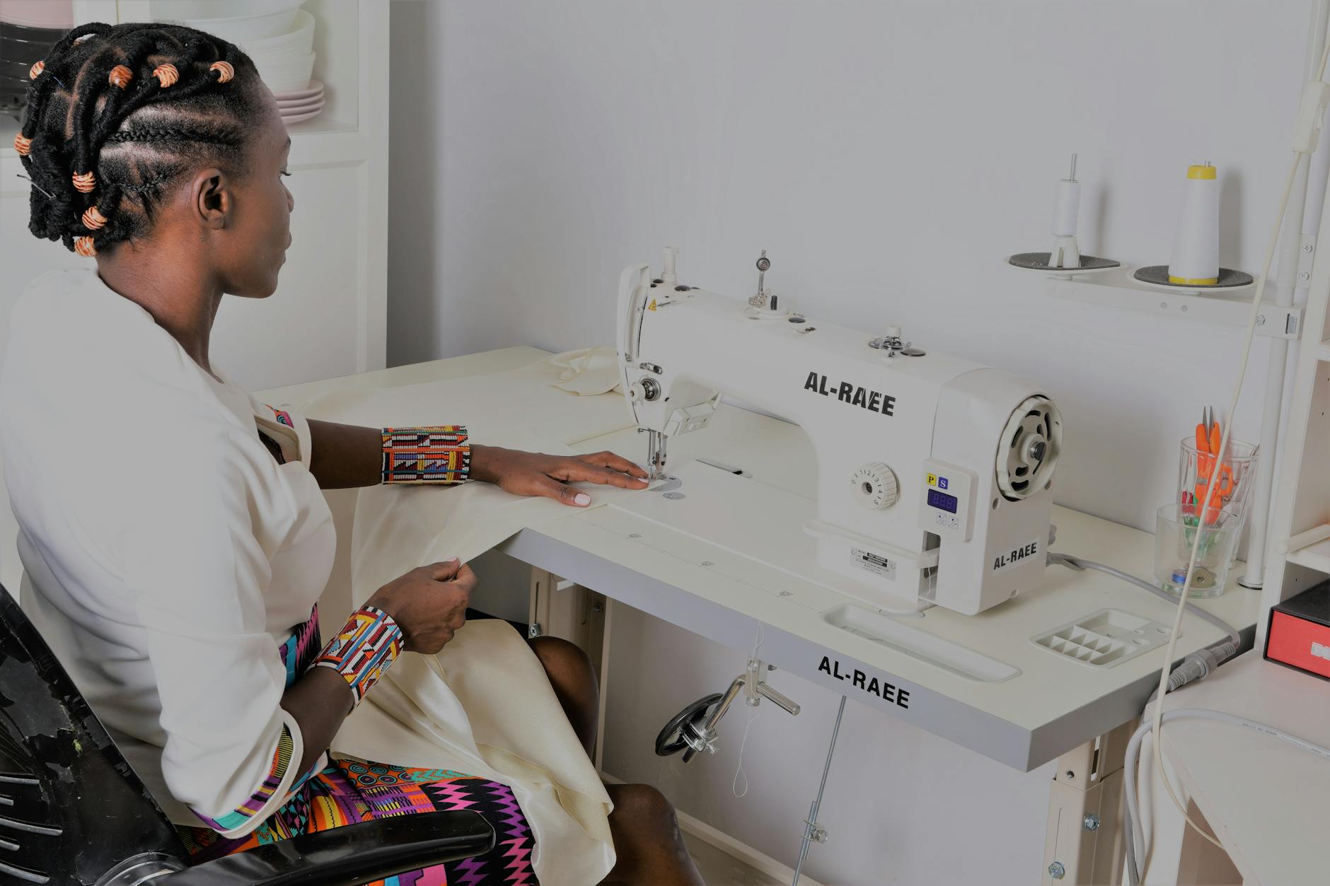 young woman sitting by a sewing machine